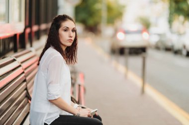 Genç ve güzel bir bayan durakta otobüs bekliyor..