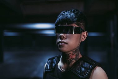 Siber punk tarzı. Bir şehirde dövmeli bir adam. Siber gözlük.