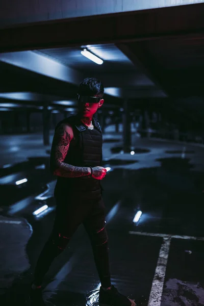 Tattooed man in the night parking lot. Cyberpunk style. Guy with cyber technology. — Stock Photo, Image