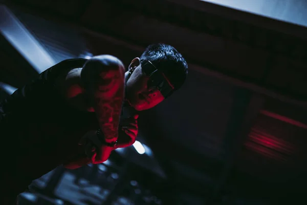 Tattooed man in the night parking lot. Cyberpunk style. Guy with cyber technology. — Stock Photo, Image