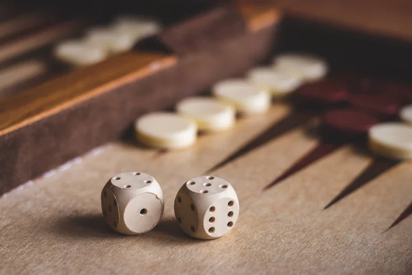 Dice on backgammon game, selective focus. Leisure game. Wooden board game.