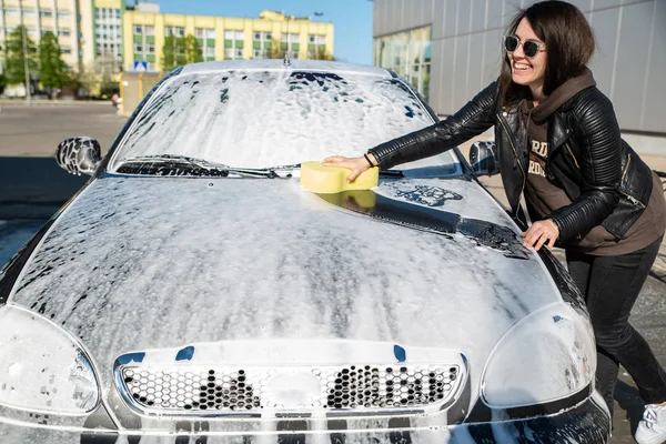 Mladá žena mytí auta na samoobslužná myčka — Stock fotografie