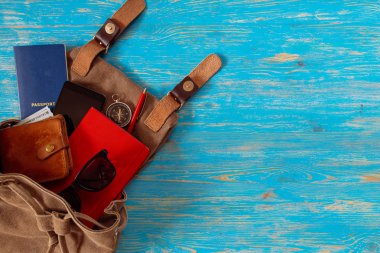 malzeme ile sırt çantası. seyahat kavramı. pasaport para güneş gözlüğü mavi ahşap zemin üzerinde. kopya alanı