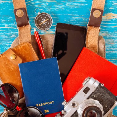 malzeme ile sırt çantası. seyahat kavramı. pasaport para güneş gözlüğü mavi ahşap zemin üzerinde. kopya alanı