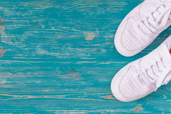 mavi ahşap arka plan üzerinde beyaz spor ayakkabı. üstten görünüm
