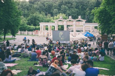 Lviv, Ukrayna - 1 Haziran 2018: Şehir Parkı açık hava sinema film izlerken çim üzerinde oturan insanlar