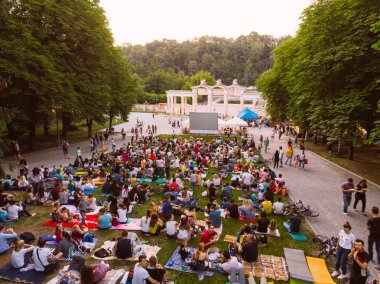 Lviv, Ukrayna - 1 Haziran 2018: Şehir Parkı açık hava sinema film izlerken çim üzerinde oturan insanlar