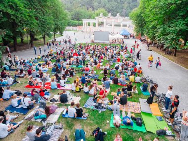 Lviv, Ukrayna - 1 Haziran 2018: Şehir Parkı açık hava sinema film izlerken çim üzerinde oturan insanlar