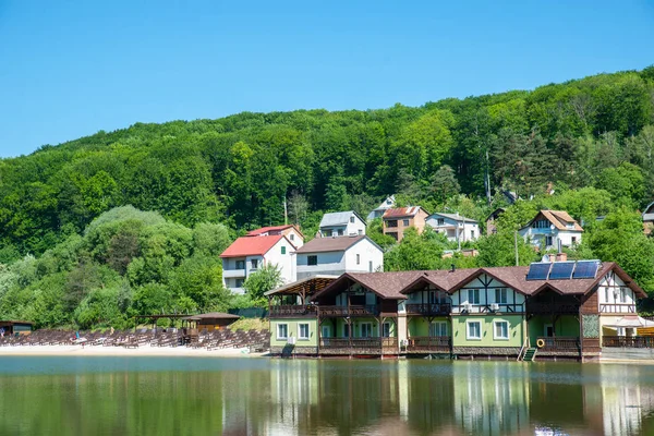 cottage on river side in sunny day with sand beach.