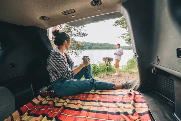 couple resting outside. car travel concept. sitting in trunk