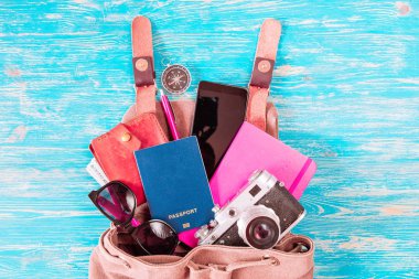 malzeme ile sırt çantası. seyahat kavramı. pasaport para güneş gözlüğü mavi ahşap zemin üzerinde. kopya alanı