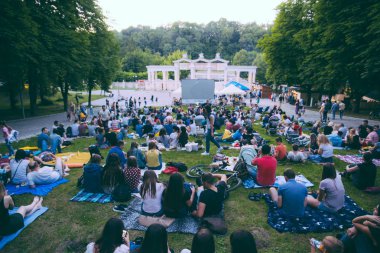 Lviv, Ukrayna - 1 Haziran 2018: Şehir Parkı açık hava sinema film izlerken çim üzerinde oturan insanlar