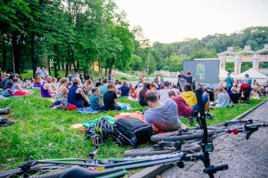 Lviv, Ukrayna - 1 Haziran 2018: Şehir Parkı açık hava sinema film izlerken çim üzerinde oturan insanlar