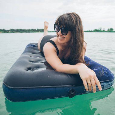 masmavi suda yüzen şişme kadın. Yaz saati kavramı