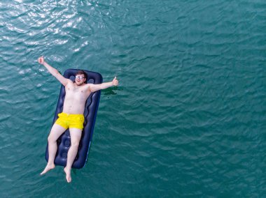 adam şişme mavi su. Yaz saati kavramı. üstten görünüm