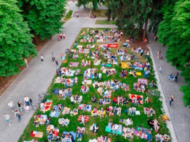 Lviv, Ukrayna - 1 Haziran 2018: Şehir Parkı açık hava sinema film izlerken çim üzerinde oturan insanlar