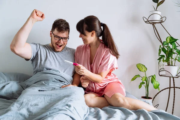 Casal Feliz Cama Mulher Mostrando Homem Teste Gravidez Positivo — Fotografia de Stock