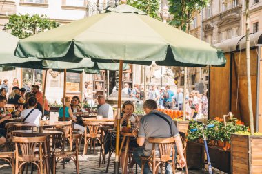 Lviv, Ukrayna - 3 Haziran 2018: Lviv sokakları, yaz aylarında dış kafede oturan insanlar