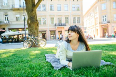 yeşil çimenlerin üzerinde Şehir Parkı içinde laptop ile döşeme Genç Yetişkin kadın