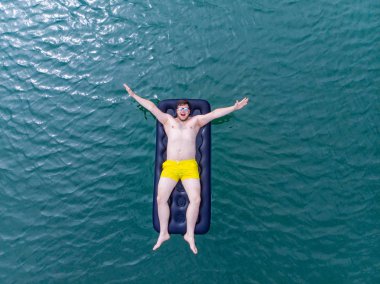 adam şişme mavi su. Yaz saati kavramı. üstten görünüm