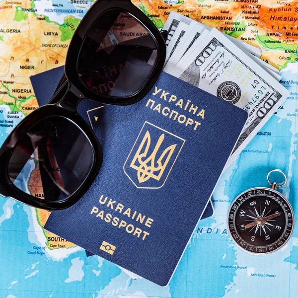travel concept. two passports with money and compass on world map and sunglasses