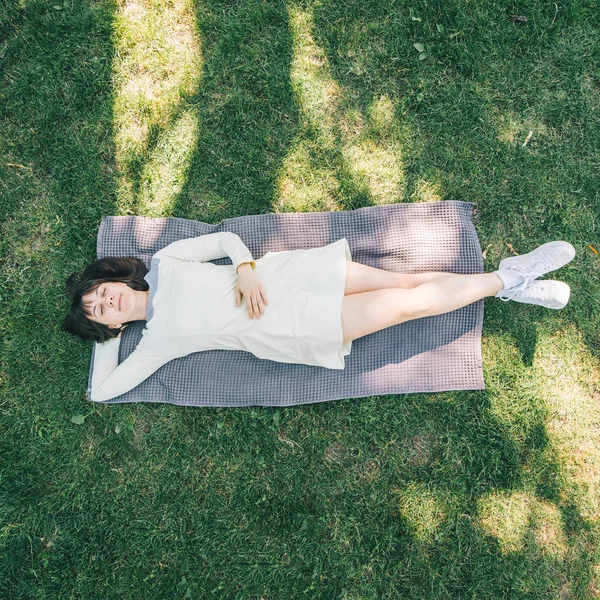 여자는 잔디에 담요에 — 스톡 사진