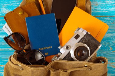 malzeme ile sırt çantası. seyahat kavramı. pasaport para güneş gözlüğü mavi ahşap zemin üzerinde. kopya alanı