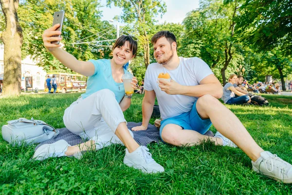 Pareja Sentada Sobre Hierba Verde Comiendo Hamburguesas Bebiendo Batido Ángel —  Fotos de Stock