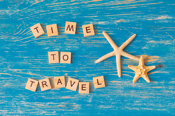 Time to travel concept. text on blue wooden background. overhead view