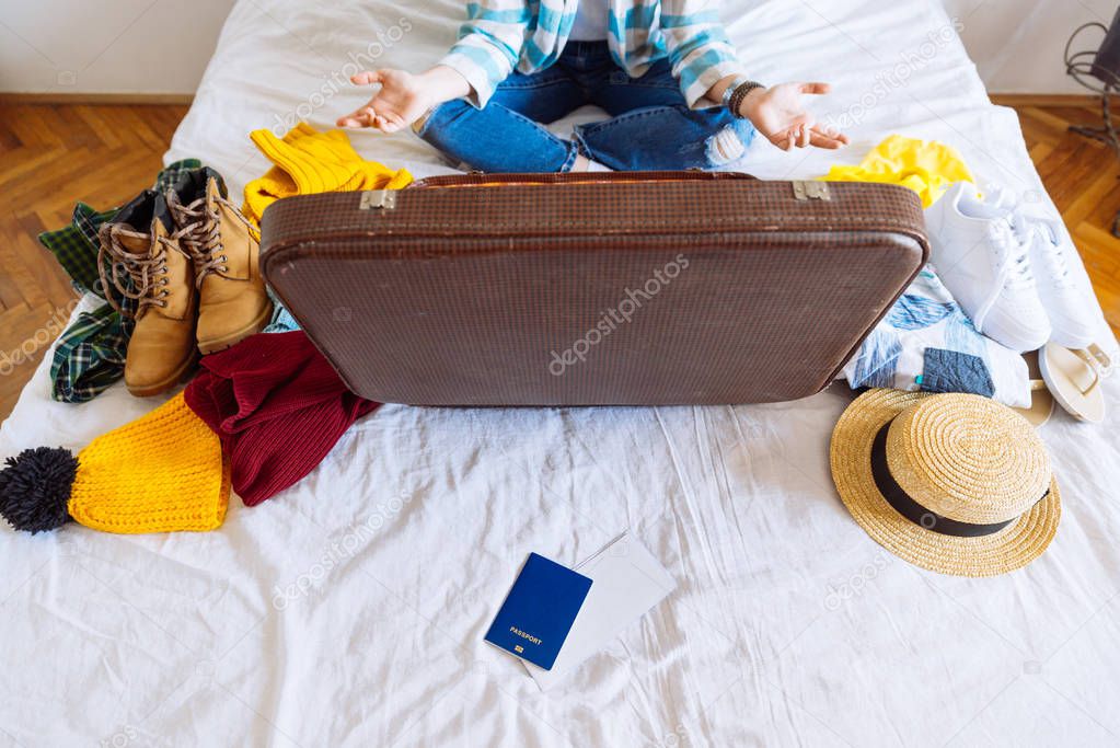suitcase with winter and summer clothes on bed. preparing for trip. suitcase with garment. travel concept