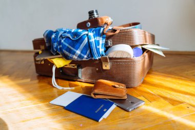 Bavul giysileri ile aşırı. seyahat kavramı. Giysi ile çanta. biyometrik pasaport önünde