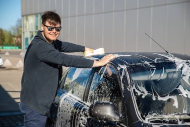 self servis carwash araba yıkama güneş gözlüklü genç adam