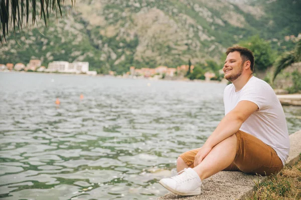 Mann Sitzt Meer Mit Schöner Aussicht Berge Hintergrund Sommerzeit — Stockfoto