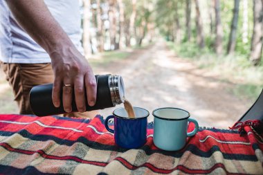 adam el kahve termosu şişe metal bardak içine dök. kopya alanı
