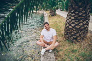 deniz kenarında güzel görünümü ile oturan adam. arka planda dağlar. Yaz saati