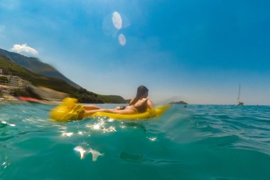Su ılık manzara plaj yan Karadağ'ın sarı şişme kadın. Yaz saati