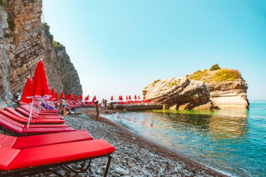 şezlong şemsiye, kayalık sahil ile. yaz tatili