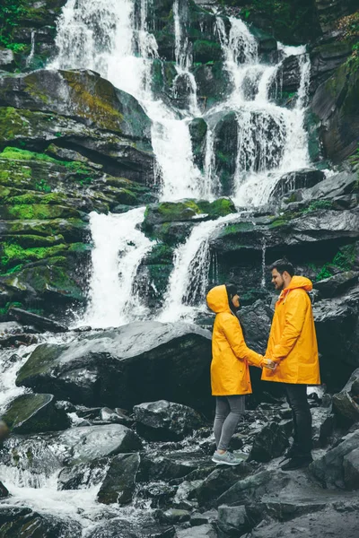 Cuplu Stând Haină Ploaie Galbenă Cascada Fundal Stil Viață — Fotografie, imagine de stoc