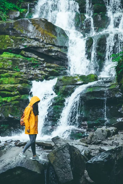 Woman Standing Rock Yellow Raincoat Waterfall Background Hiking Concept — Stock Photo, Image