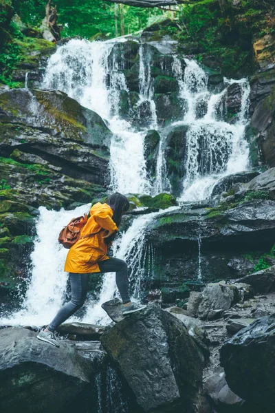Frau Springt Gelben Regenmantel Von Felsen Felsen Wald Wasserfall Auf — Stockfoto
