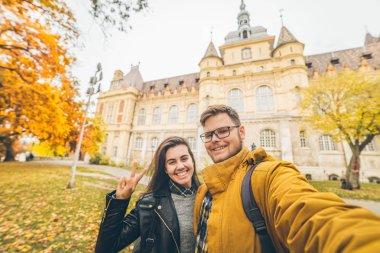 Şehir Park arka plan kalede ile çift alarak selfie. Sonbahar geliyor. kopya alanı