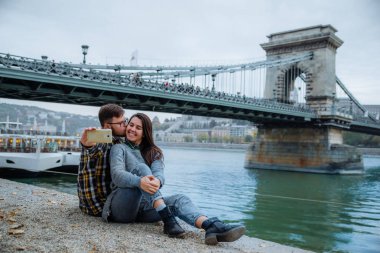 Genç çift, arka plan üzerinde eski zincir köprü sarıl. Budapeşte, Macaristan