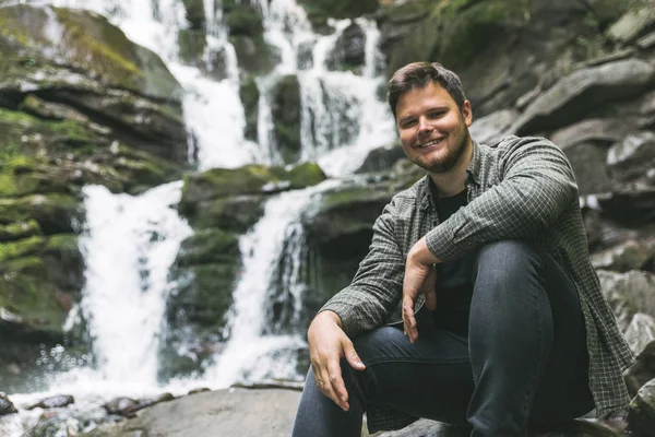 Mann Sitzt Auf Einem Felsen Mit Wasserfall Hintergrund Reisekonzept — Stockfoto