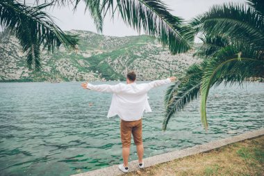 deniz kenarında güzel görünümü ile oturan adam. arka planda dağlar. Yaz saati