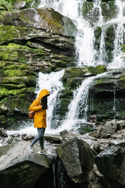 Woman Standing Rock Yellow Raincoat Waterfall Background Hiking Concept — Stock Photo, Image