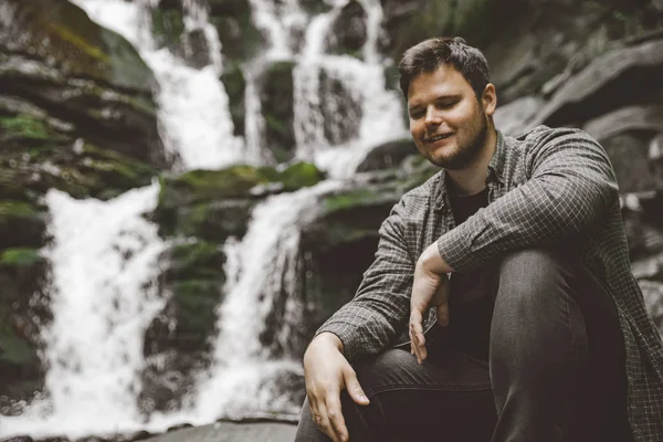 Mann Sitzt Auf Einem Felsen Mit Wasserfall Hintergrund Reisekonzept — Stockfoto