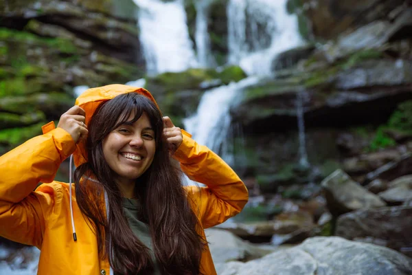 Donna Sorridente Impermeabile Giallo Con Cascata Sullo Sfondo Concetto Trekking — Foto Stock