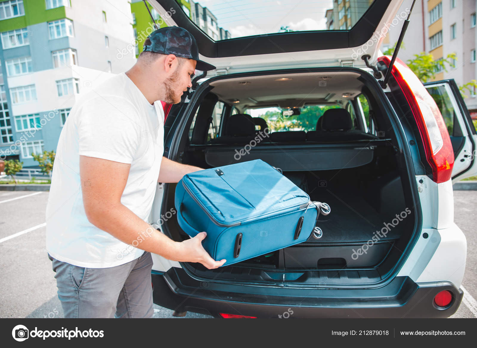 Hombre poniendo bolsas en el maletero del coche listo para viajar en coche