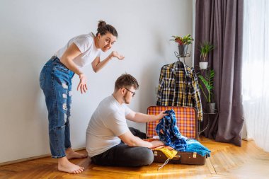 Dostum kadın sevk yardıma ihtiyacım var. seyahat kavramı. çalışan adam seyahat çantası içinde elbise uygun.