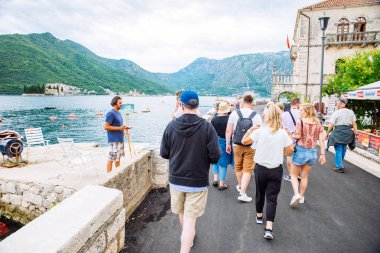 Perast, Karadağ - 17 Temmuz 2018: Grup Adriyatik Denizi yakınlarında Perast kasaba tarafından turistler yürüyüş. yaz seyahat kavramı